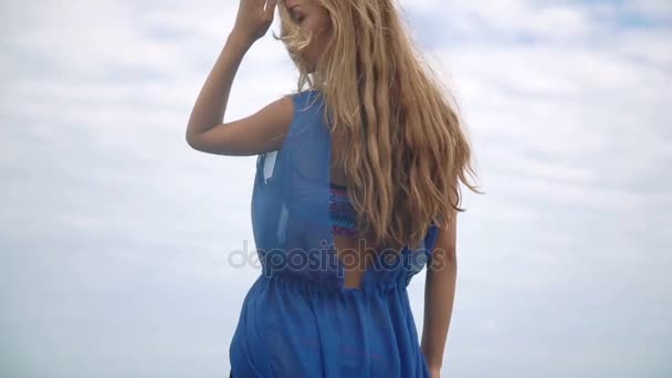 Gorgeous young girl with a beautiful figure posing and walks along the seashore — Stock Video