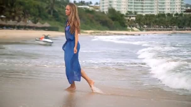 Gyönyörű fiatal lány egy szép szám jelentő és sétákat a tengerparton — Stock videók