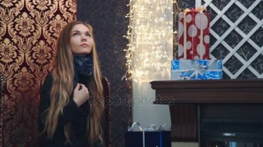 Şöminenin yanında genç bir kadın, Noel ağacı yakın bir sandalyede oturan kadın portresi oturan güzel kız