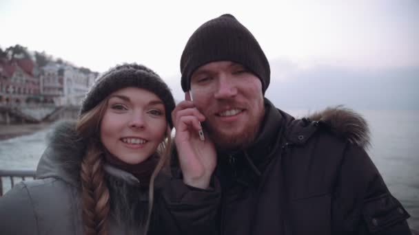 Par man och kvinna på piren titta på havet — Stockvideo