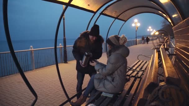In liefde en gelukkige paar zittend op een bankje bij de zee. — Stockvideo