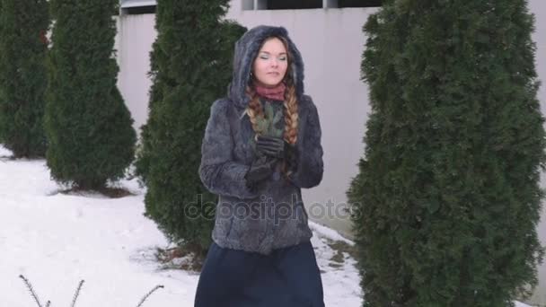 Молода красива жінка позує над зимовим лісом. Відкритий зимовий портрет над засніженим тлом. повільний рух від 50 кадрів на секунду Full HD — стокове відео