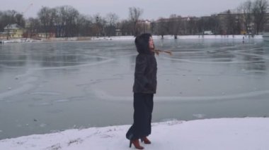 Genç güzel kadın kış orman üzerinde poz. Karlı arka plan üzerine açık kış portre. yavaş hareket 50 fps Full Hd