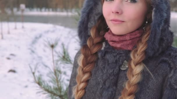 Joven mujer hermosa posando sobre el bosque de invierno. Retrato de invierno al aire libre sobre fondo nevado. cámara lenta de 50 fps Full HD — Vídeos de Stock