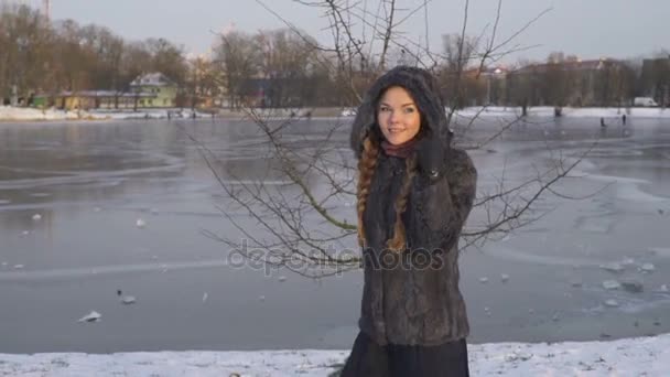 Mulher bonita jovem posando sobre floresta de inverno. Retrato de inverno ao ar livre sobre fundo nevado. câmera lenta a partir de 50 fps Full HD — Vídeo de Stock