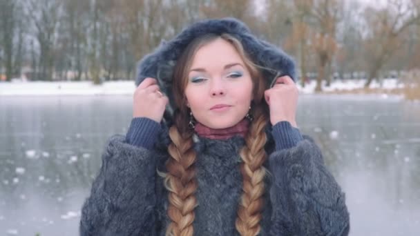 Mulher bonita jovem posando sobre floresta de inverno. Retrato de inverno ao ar livre sobre fundo nevado. câmera lenta a partir de 50 fps Full HD — Vídeo de Stock