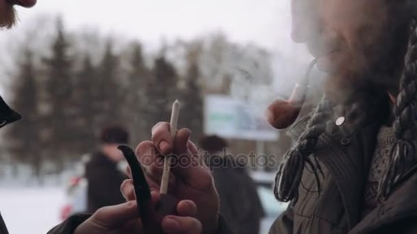 Two man with a beard in the winter get a light pipe — Stock Video