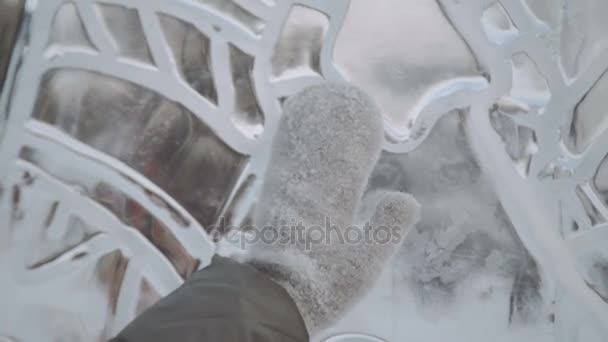 Молодая женщина улыбается ледяным скульптурам, зимние перчатки крупным планом — стоковое видео