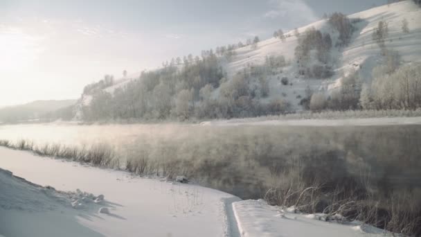 Rivière de montagne tôt le matin. La vapeur monte sur l'eau dans les rayons du soleil levant .