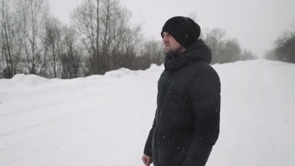 Retrato de un joven guapo con barba. Un hombre barbudo en el bosque de invierno. Hombre barbudo joven sano en la naturaleza . — Vídeo de stock