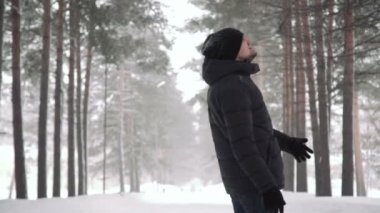 Sakallı genç yakışıklı bir adam portresi. Sakallı bir adam kış ormanın içinde. Doğada sağlıklı genç sakallı adam.