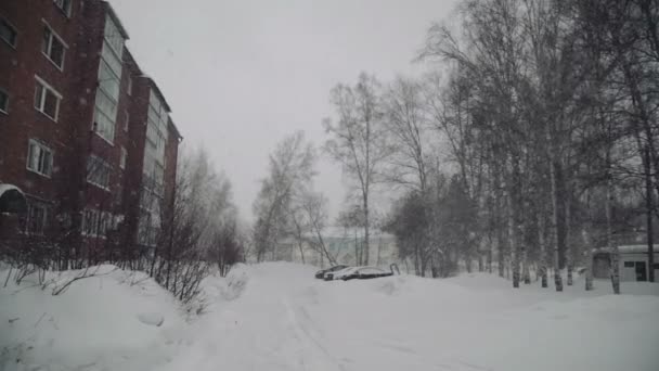 Ciudad en invierno, nieva en la calle, casas planas, árboles — Vídeos de Stock