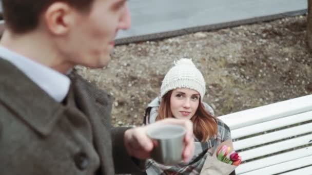 De man is het drinken van thee uit de thermos, lacht, kijken naar de vrouw. Koud weer, close-up, levensstijl, geluk — Stockvideo