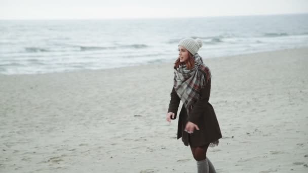 对年轻的夫妇跑到彼此，跳和笑，笑话，乐趣上海滩，大衣和帽子，波罗的海或冰岛寒冷的天气 — 图库视频影像