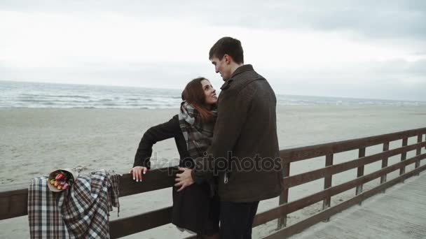 Young couple looking at the sea, walking the beach, coat and hat, Baltic or Iceland cold weather — Stock Video