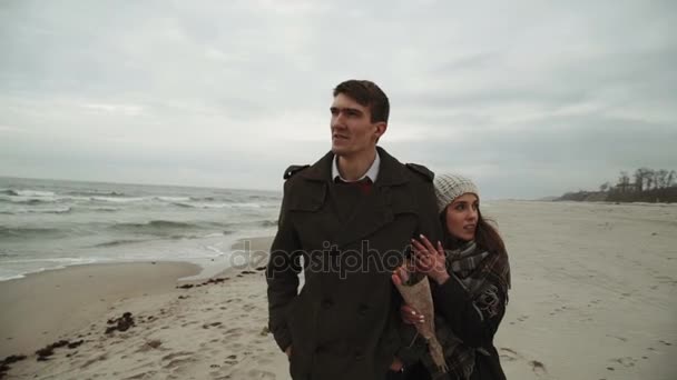 Fiatal pár keres a tengeren, séta a strand, kabát és kalap, a Balti, Izland vagy hideg időjárás
