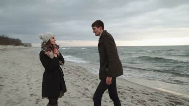 Jeune couple regardant la mer, marchant sur la plage, manteau et chapeau, Baltique ou Islande temps froid — Video