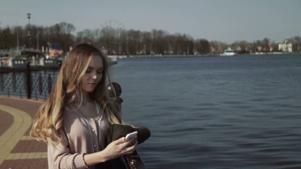 Junge schöne Frau im Stadtpark am See — Stockvideo