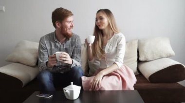 Çift dan bir beyaz çay çay içmek evde kanepe kanepede oturan ve tv izlerken.