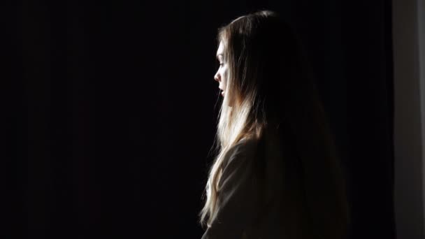 Sötét háttér egy fiatal nő portréja. Stúdió felvétel-alacsony kulcs világítással — Stock videók