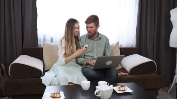 Çift laptop perde ve gülümseme göz evde kanepe kanepede oturuyor — Stok video