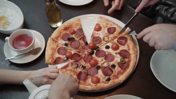 Mãos a cortar pizzas Vista superior, tiro de perto. Em um café, comunicação e amigos — Vídeo de Stock