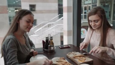 İki genç kadın bir kafede bir araya geldi arkadaşlar iş yemeği. Konuşmak ve meyilli balık yiyin
