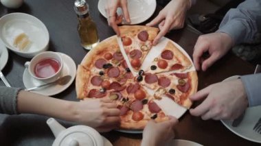 Eller, pizza kesim üstten görünüm alarak yakın çekim vurdu. Bir kafe, iletişim ve arkadaşlar