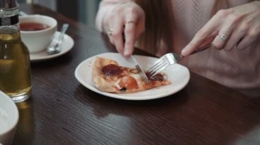 Bir el keser ve bir dilim pizza, yakın çekim vurdu yiyor. Bir kafe, iletişim ve arkadaşlar