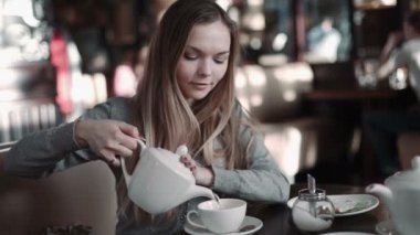 Genç çekici kadın kahve veya çay içme kafede, steadicam vurdu