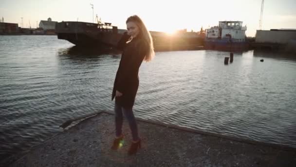 Mujer cepillándose el pelo y bailando al atardecer puerto del río, deslumbramiento del sol en la lente — Vídeos de Stock