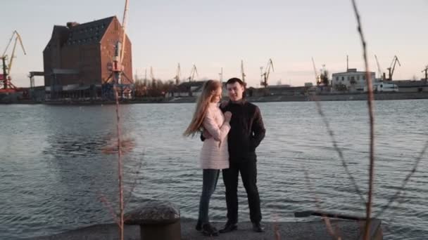 Привлекательная романтическая пара, смотрящая на лодки в гавани. в море, гуляя и наслаждаясь красивым закатом, целуясь и обнимаясь . — стоковое видео