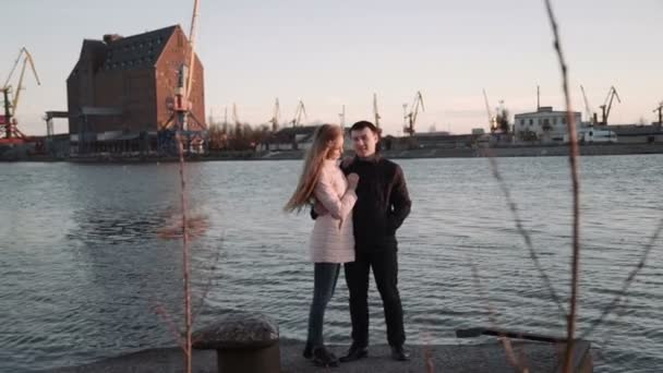 Casal romântico atraente olhando para os barcos no porto. no porto, andando e desfrutando de belo pôr do sol, beijando e abraçando . — Vídeo de Stock