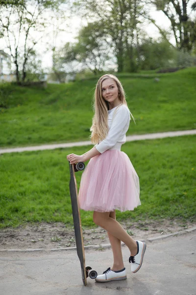 Jonge vrouw zomer longboard roze rokje tutu poorten rok Stockafbeelding