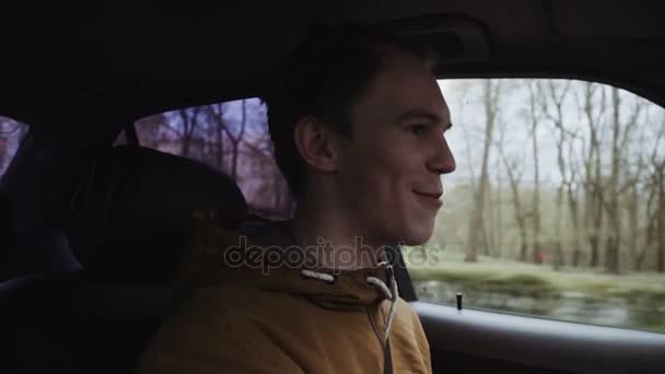 Νεαρός άνδρας οδηγεί ένα αυτοκίνητο. Μέσα βολής — Αρχείο Βίντεο