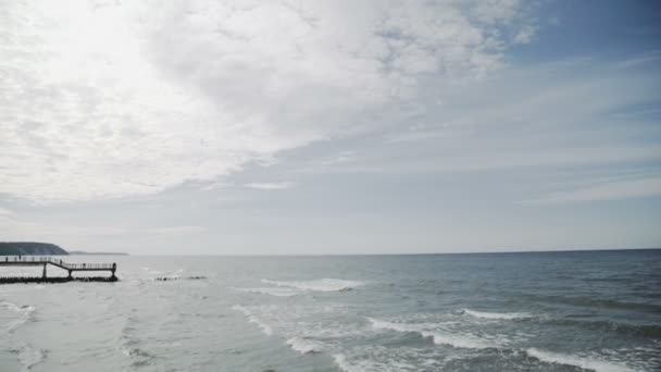 El Mar Báltico, olas. El pueblo de mar del muelle y la playa . — Vídeo de stock