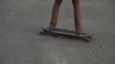 Kızıl saçlı genç adam sakallı longboard başlar yolculuk günbatımı Park ayak. Yakın çekim