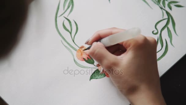 Bir genç kadın sanatçı, suluboya ile boyalar su fırça çiçek çelenk yeşil yaprakların boyar. yakın çekim — Stok video
