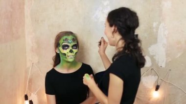kadının aquagrim yüz sanat halloween makyaj elleri üzerinde yapması yeşil korkunç göz alıcı iskelet püsküller. Meksikalı Prenses şeker kafatası.