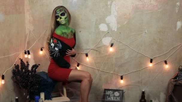 Aquagrim ansikte konst på halloween tofsar grön skrämmande glamorösa strass skelett. Mexikanska Princess socker skalle. kvinna modell poserar framför kameran i röd klänning. — Stockvideo