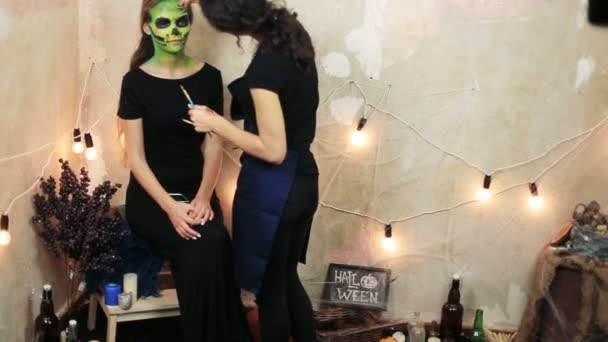 Mujer haciendo aquagrim arte de la cara en el maquillaje de Halloween con sus manos borlas verde esqueleto glamoroso miedo. Cráneo de azúcar princesa mexicana . — Vídeos de Stock