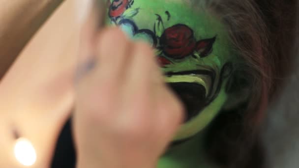 Frau, die Aquagrim-Gesichtskunst auf Halloween-Make-up mit ihren Händen Quasten grün beängstigend glamourös Skelett. mexikanische Prinzessin Zucker Schädel. — Stockvideo