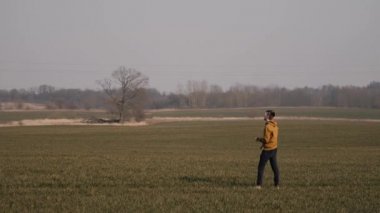 Genç sporcu sahada koşar ve gökyüzüne bir bumerang fırlatır.