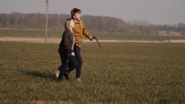 Young couple in love together launch a boomerang in a field — Stock Video