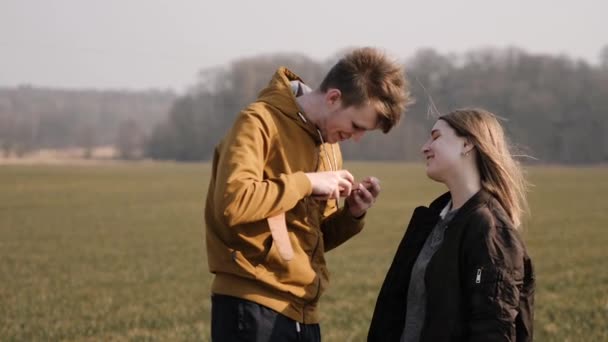 Joven pareja hombre y mujer de pie al aire libre hablando y riendo — Vídeo de stock