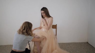 Genç bir kadın fotoğrafçı. Gelinlik giymiş güzel bir mankenin fotoğrafını çekiyor.