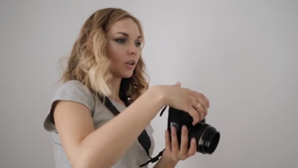 Молодая женщина фотограф учит модель позировать — стоковое видео