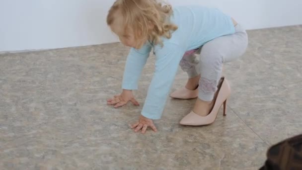 Une petite fille entre dans les talons hauts roses de ma mère et tombe — Video