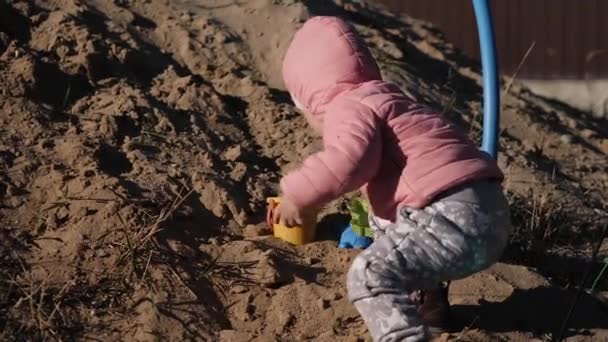 Liten flicka leker i en sandlåda — Stockvideo