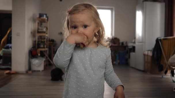 Den lilla flickan springer snabbt in i rummet från kameran ser tillbaka — Stockvideo